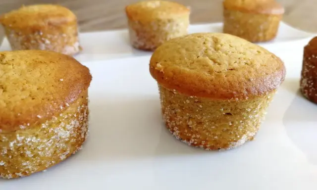 Six muffins dorés, certains légèrement inclinés, sur une assiette blanche. Peut-être que c'est pour ça que mes muffins gonflent de travers !