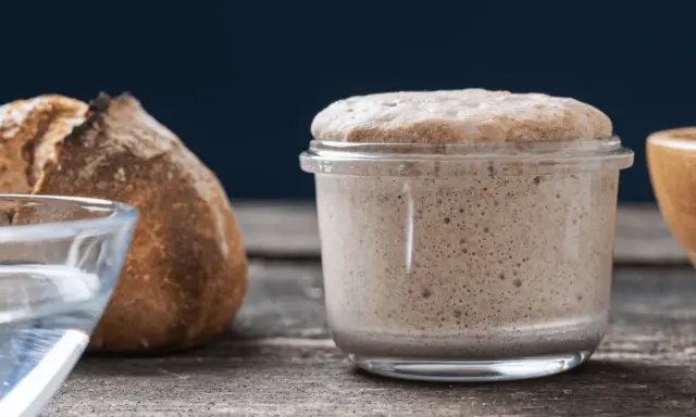 Un bocal de levain actif, plein de bulles, prêt à faire du pain. Ce type de levure est essentiel pour une mie aérée.