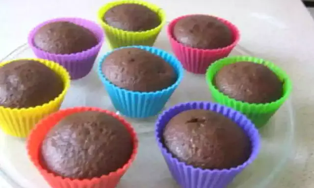 Huit cupcakes au chocolat, prêts à être dégustés, dans des moules colorés. Une recette de cupcake au chocolat facile et rapide.