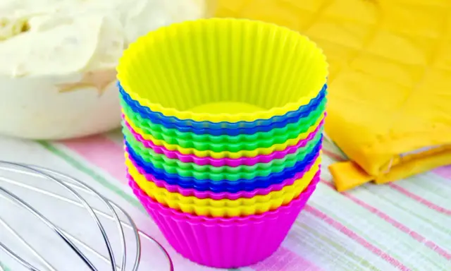 Pile de moules à cupcakes en silicone multicolores, prêts pour la pâtisserie. Apprenez comment nettoyer des moules en silicone pour qu'ils durent longtemps.