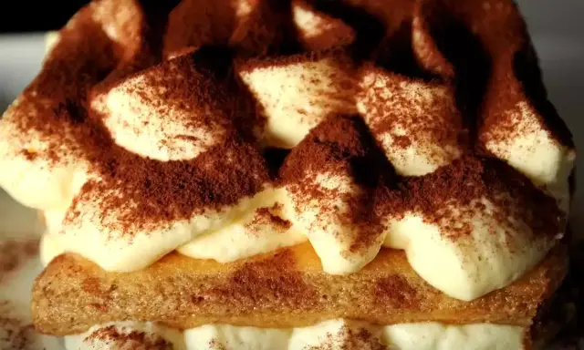 Un délicieux tiramisu au marsala, garni de cacao, avec des couches de crème onctueuse et de biscuits savoiardi.