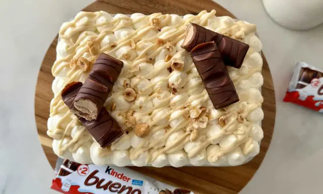 Un délicieux tiramisu Kinder Bueno, garni de morceaux de chocolat et de noisettes concassées. Un vrai régal pour les amateurs de chocolat !