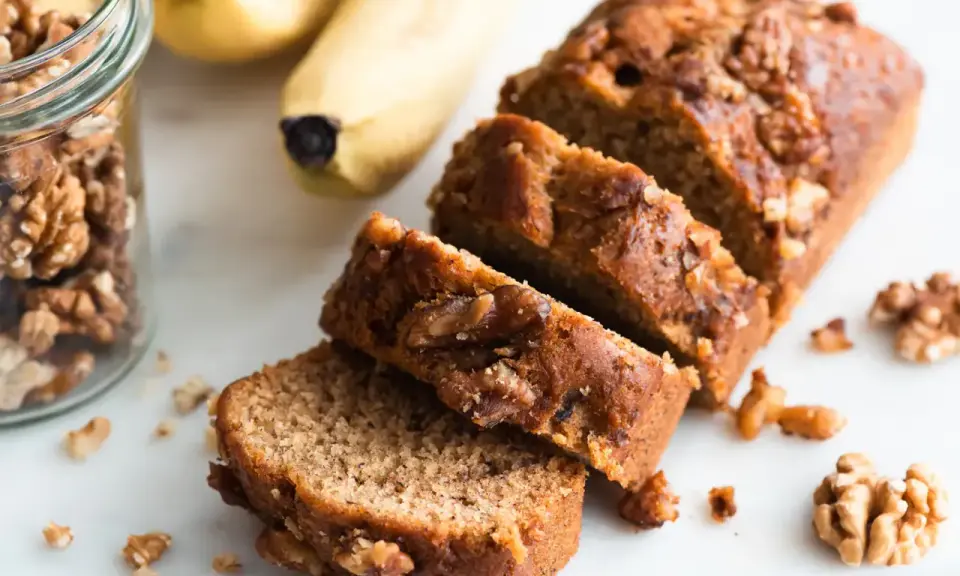 Tranches de délicieux dessert banane et noix, avec des bananes et des noix à proximité.
