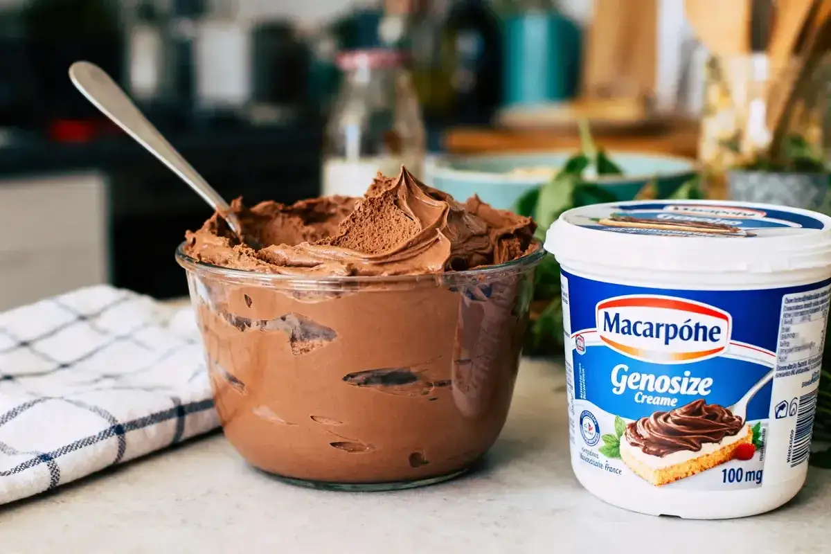 Un bol de délicieuse crème mascarpone au chocolat, prêt à être dégusté. À côté, un pot de la même crème.