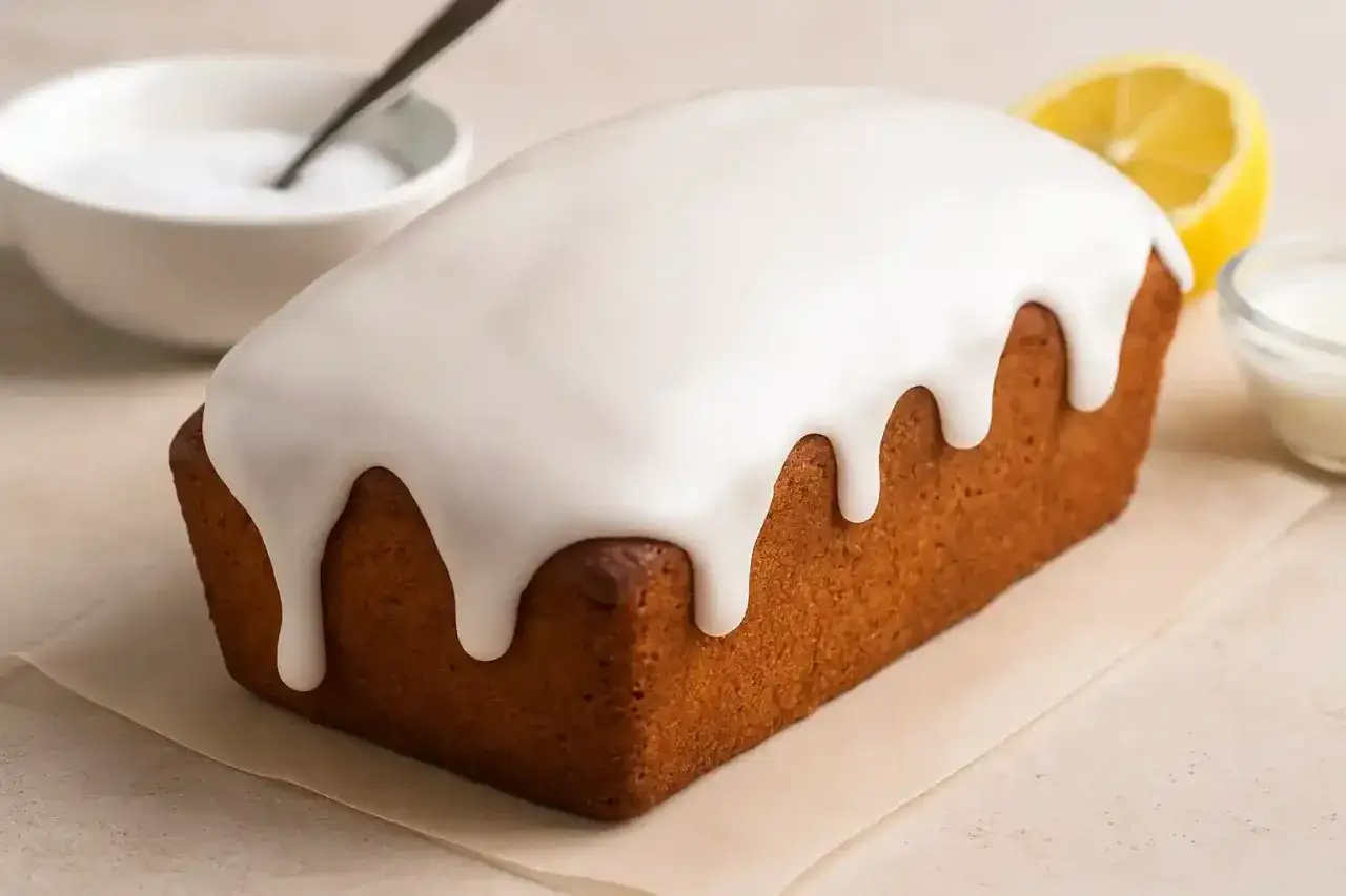 Gâteau doré nappé d'un glaçage blanc dégoulinant. Parfait pour un glaçage sur gâteau froid ou chaud, avec une touche de citron.