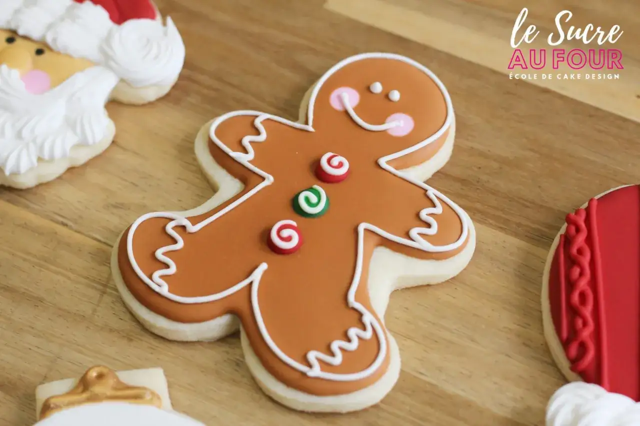 Un biscuit bonhomme pain d'&eacute;pice souriant, d&eacute;cor&eacute; de glacage royal, avec des touches de rouge et vert.