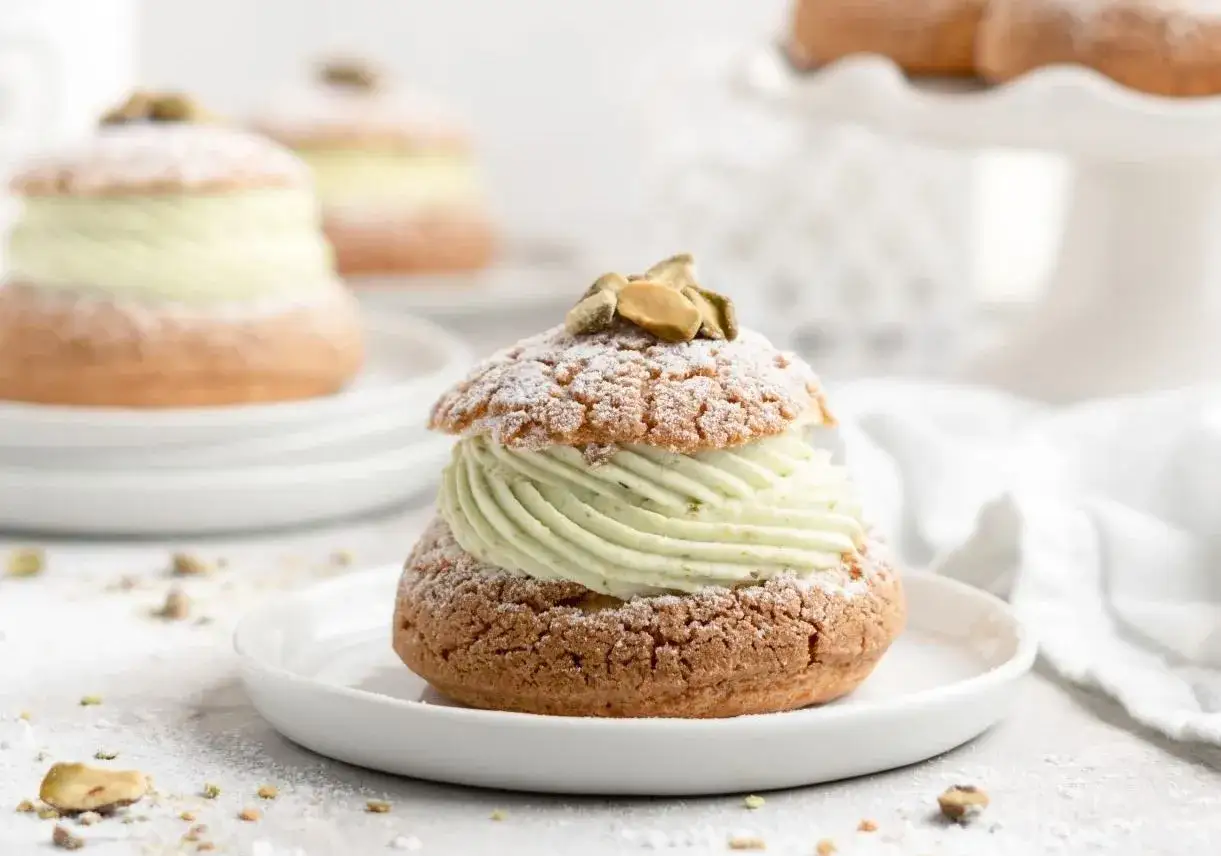 Délicieux choux garnis d'une crème onctueuse. Une recette ganache pistache sans chocolat blanc pour un dessert léger et gourmand.