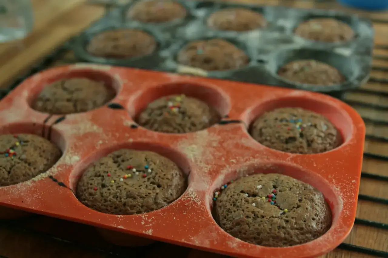 Muffins au chocolat dans un moule orange. Apprenez comment nettoyer des moules en silicone pour r&eacute;utiliser ces moules.