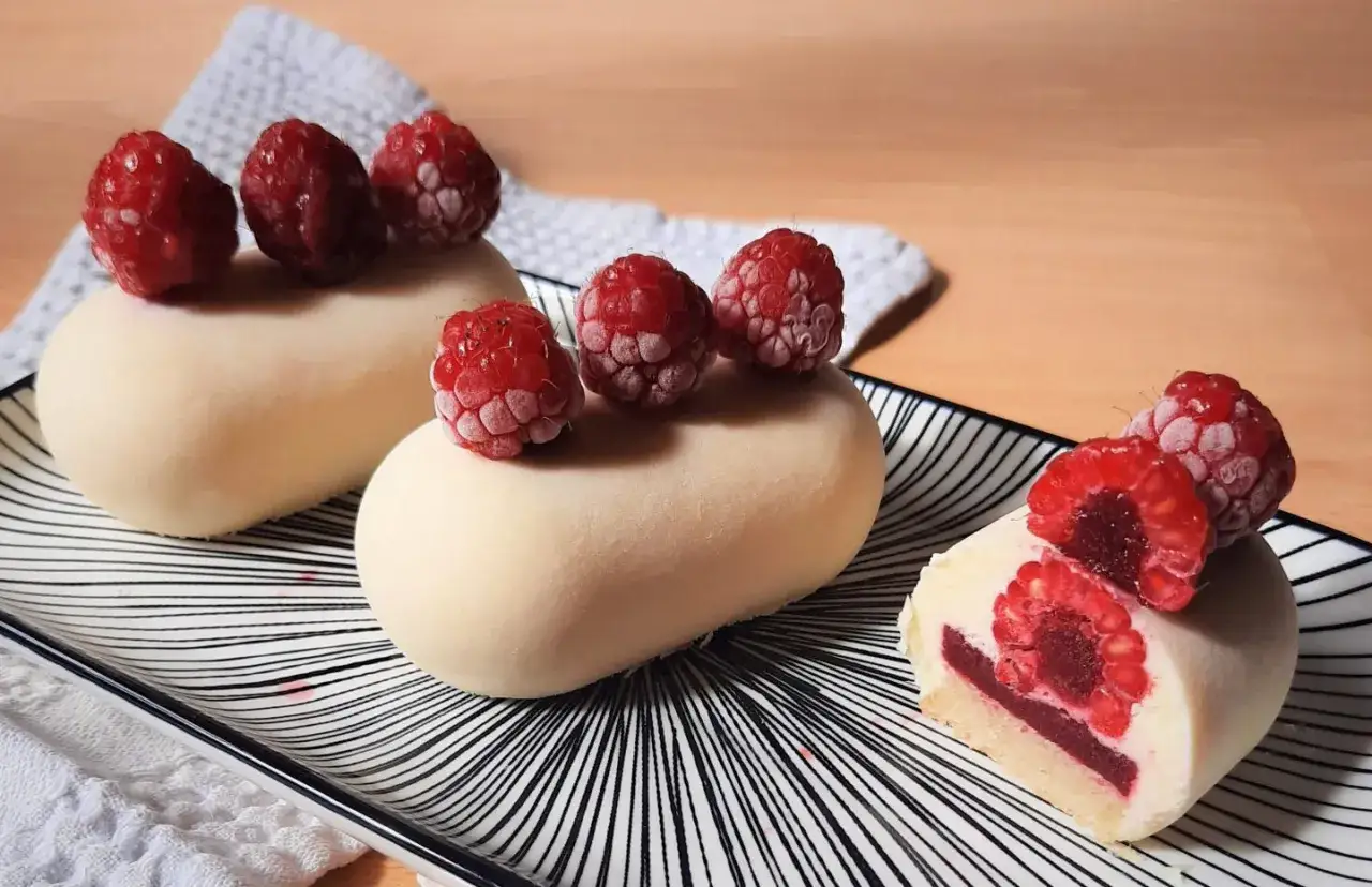 Gourmandises blanches ornées de framboises fraîches. Un nappage framboise facile pour sublimer ces douceurs.