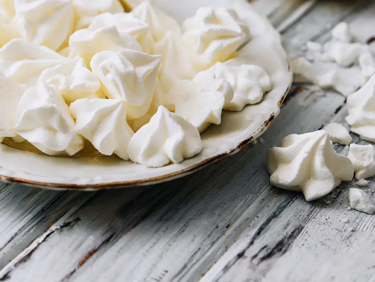 Meringues aériennes sur une assiette, comme celles de Cyril Lignac. Croustillantes et fondantes, un délice !