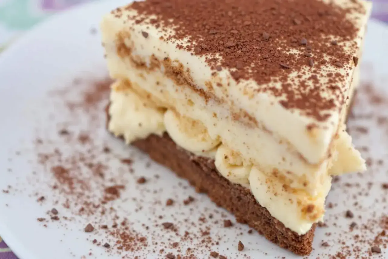 Tranche de tiramisu onctueux, saupoudr&eacute;e de cacao. Combien de temps au frigo pour qu'il soit parfait ?