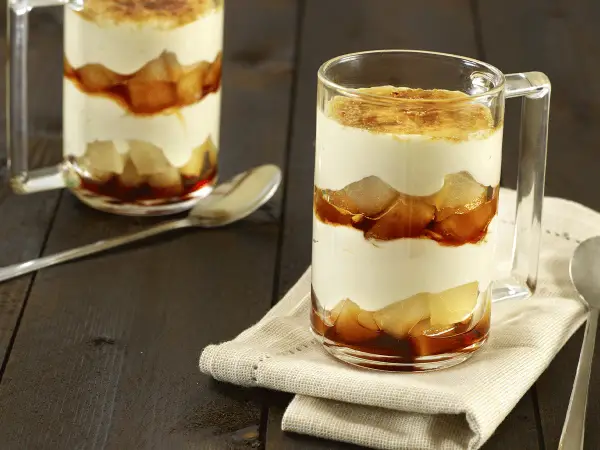 Un délicieux tiramisu poire, superposé en couches dans un verre, avec une touche caramélisée sur le dessus.