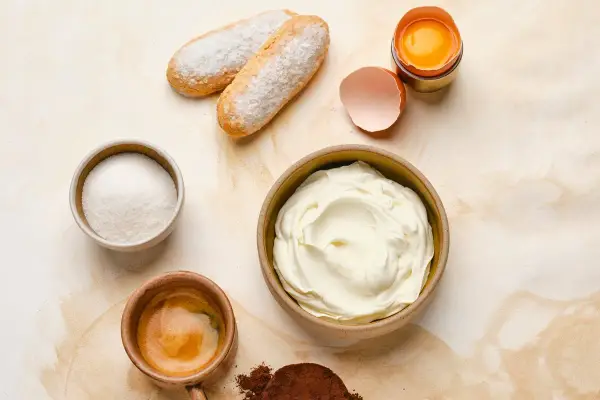 Ingrédients pour un tiramisu : boudoirs, sucre, café, cacao, œuf et un grand bol de mascarpone 500g.