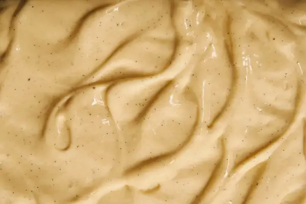 Texture onctueuse de crème pâtissière mousseuse, parsemée de points de vanille.