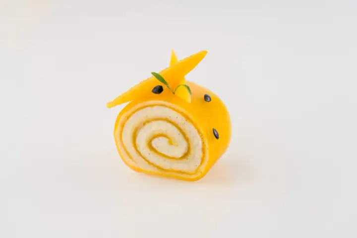Un adorable petit roulé jaune, décoré comme un animal, montre ce que faire avec de la purée de fruits.
