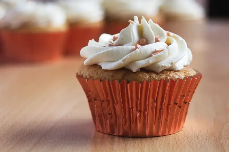 Un cupcake orné d'une ganache montée au chocolat blanc, prêt à être dégusté. Une recette simple pour un dessert gourmand.
